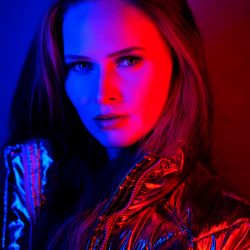 junge Frau in rotem und blauem Blitzlicht